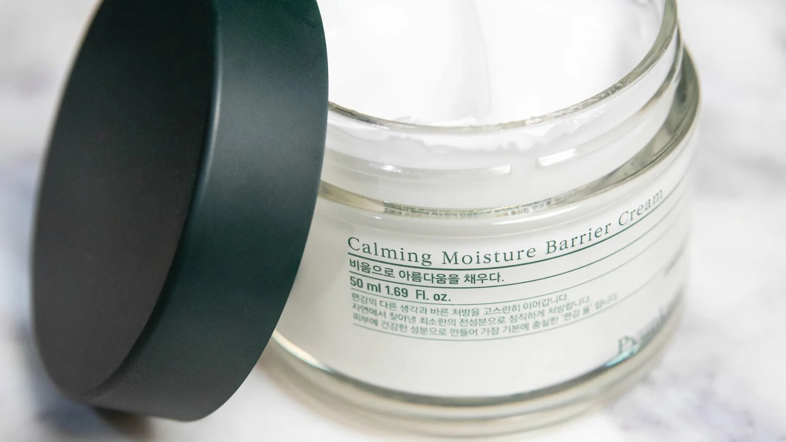 An open jar of moisturising cream representing skin-barrier care.